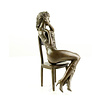 A bronze sculpture of an enticing female seated on a chair
