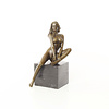 A bronze sculpture of a sitting female nude