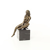 A bronze sculpture of a sitting female nude