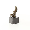 A bronze sculpture of a sitting female nude