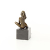 A bronze sculpture of a sitting female nude