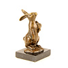 Bronze sculpture of a rabbit holding a carrot