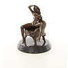 An erotic bronze sculpture of a sitting nude female