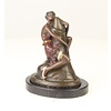 Bronzen beeld van een vrouw die een fallus omhelst