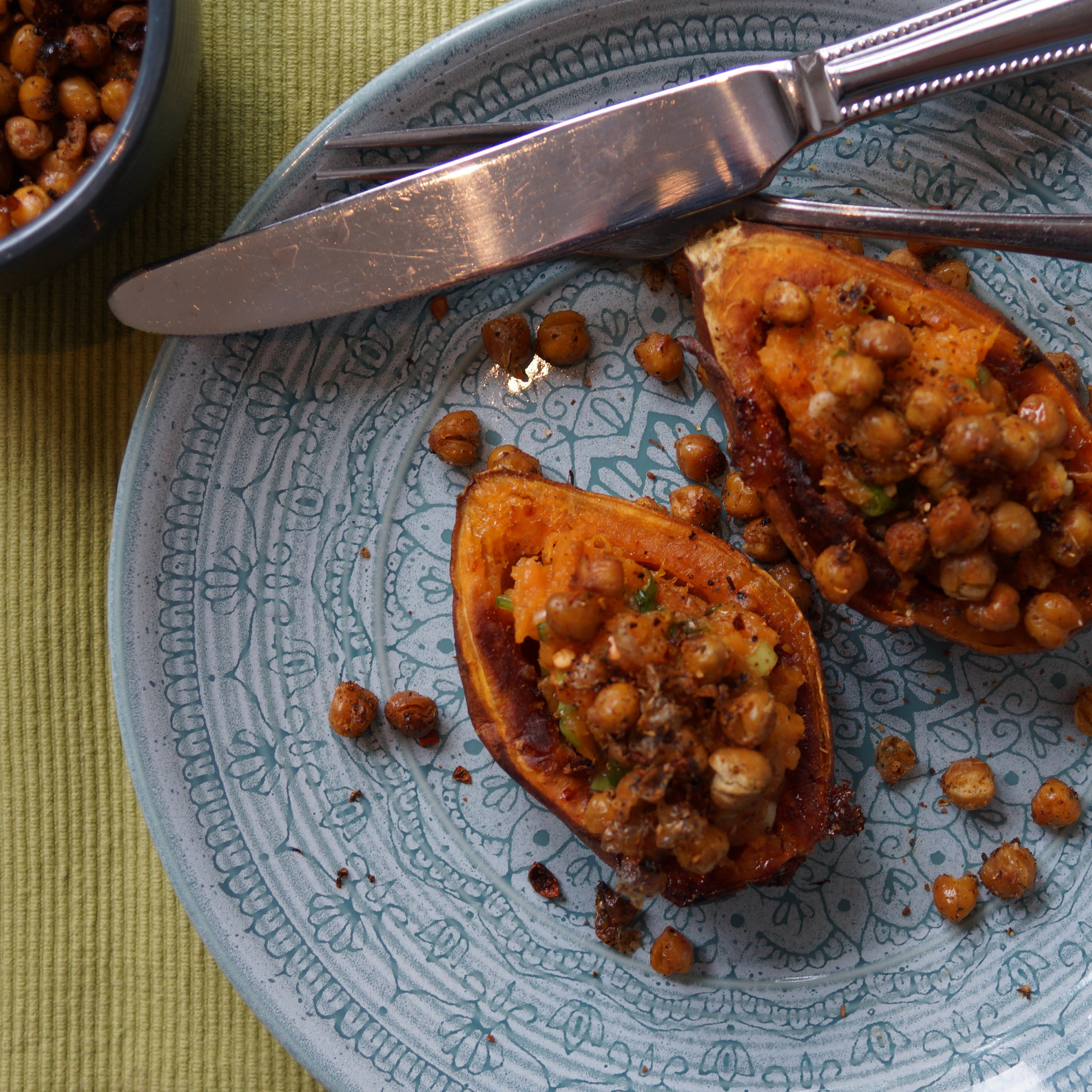 Zoete aardappel met lente-ui puree en knapperige kikkererwten op bord