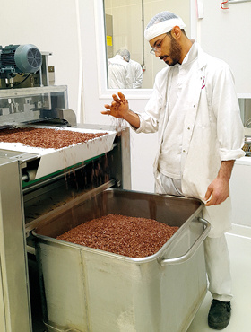 Een medewerker in een witte jas produceert hagelslag