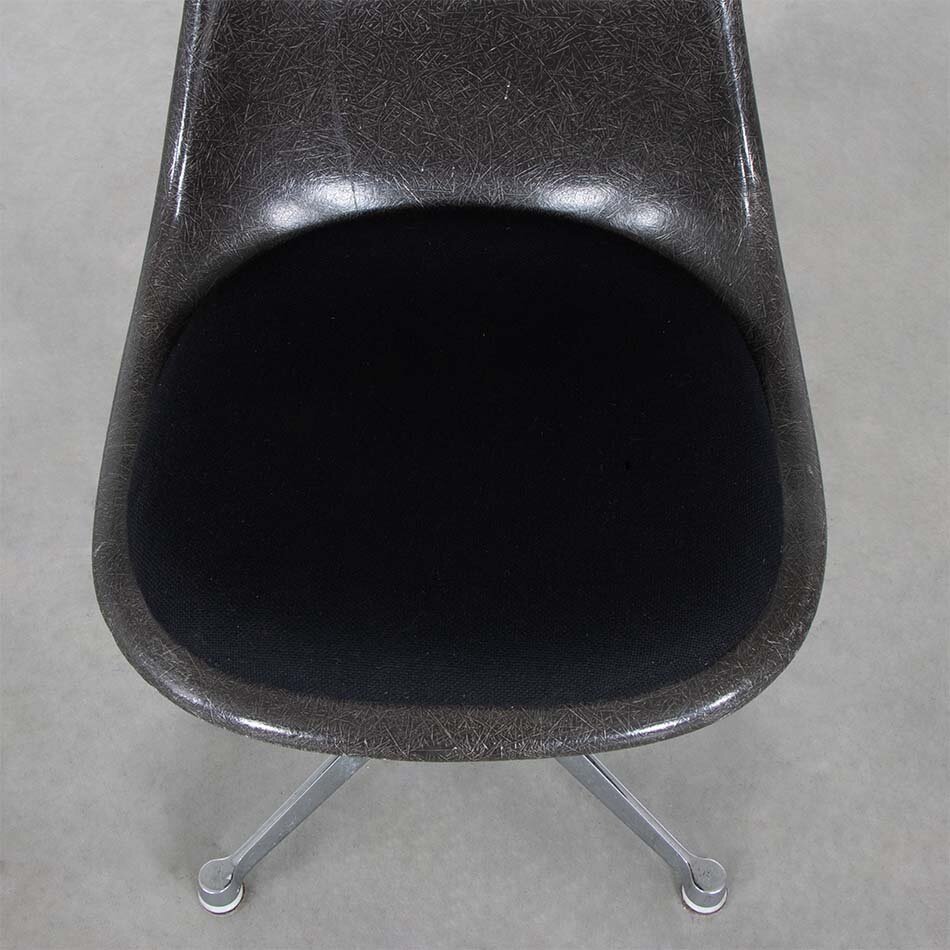 Eames brown fiberglass chair with upholstered seat and height-adjustable swivel leg