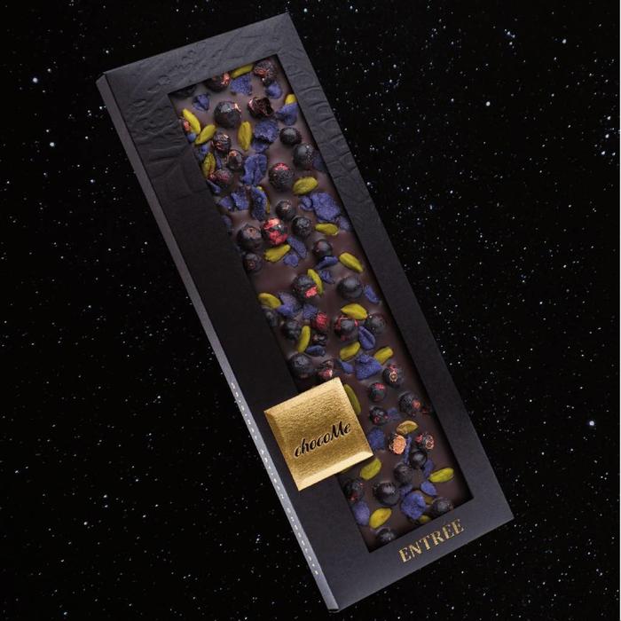 - ENTRÉE | SYRAH II | Valrhona dunkle Schokolade 66% mit Pistazien aus Bronte, kandierte Veilchen und gefriergetrocknete Schwarze Johannisbeere, 110g