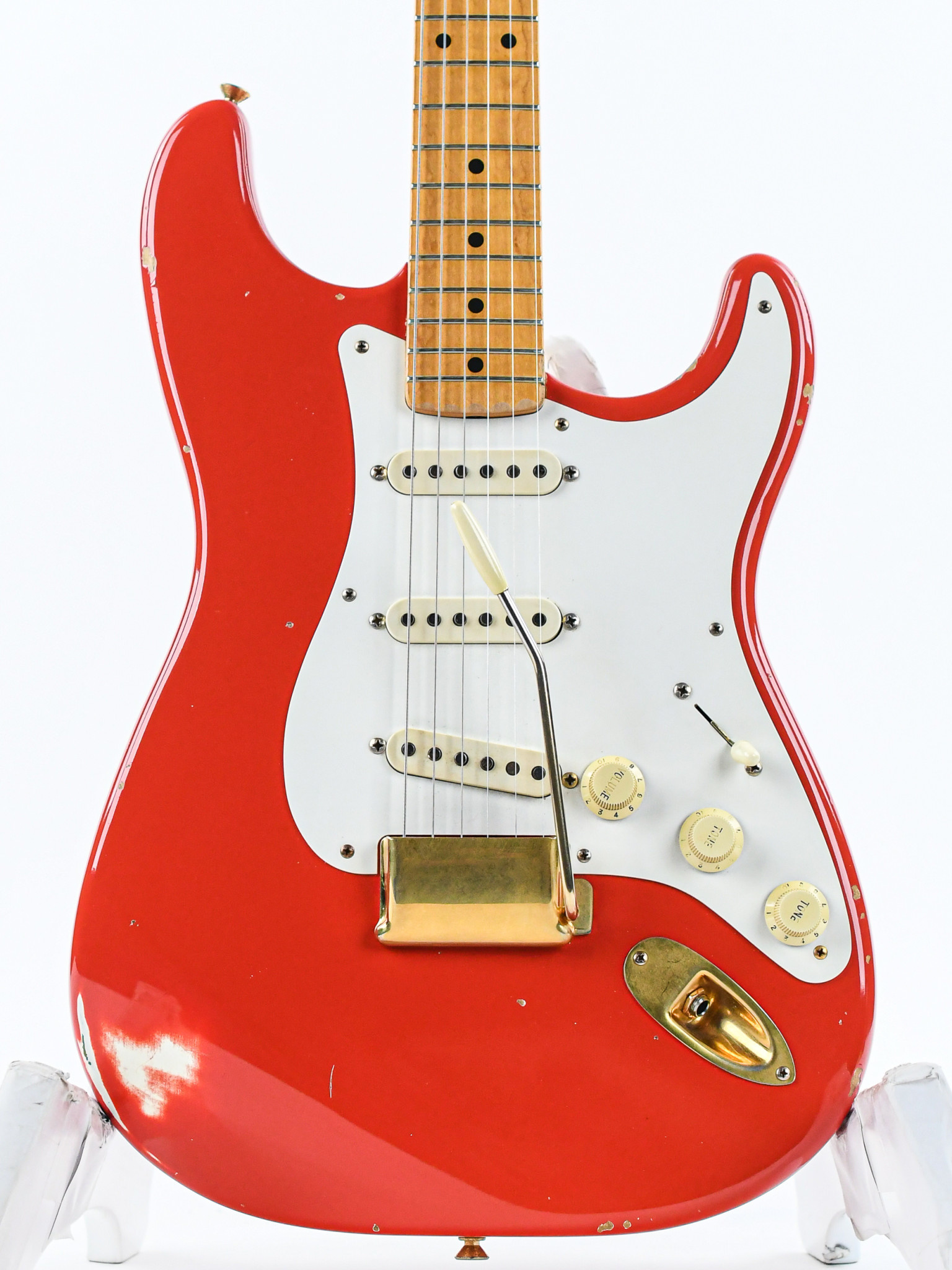 red and white fender electric guitar