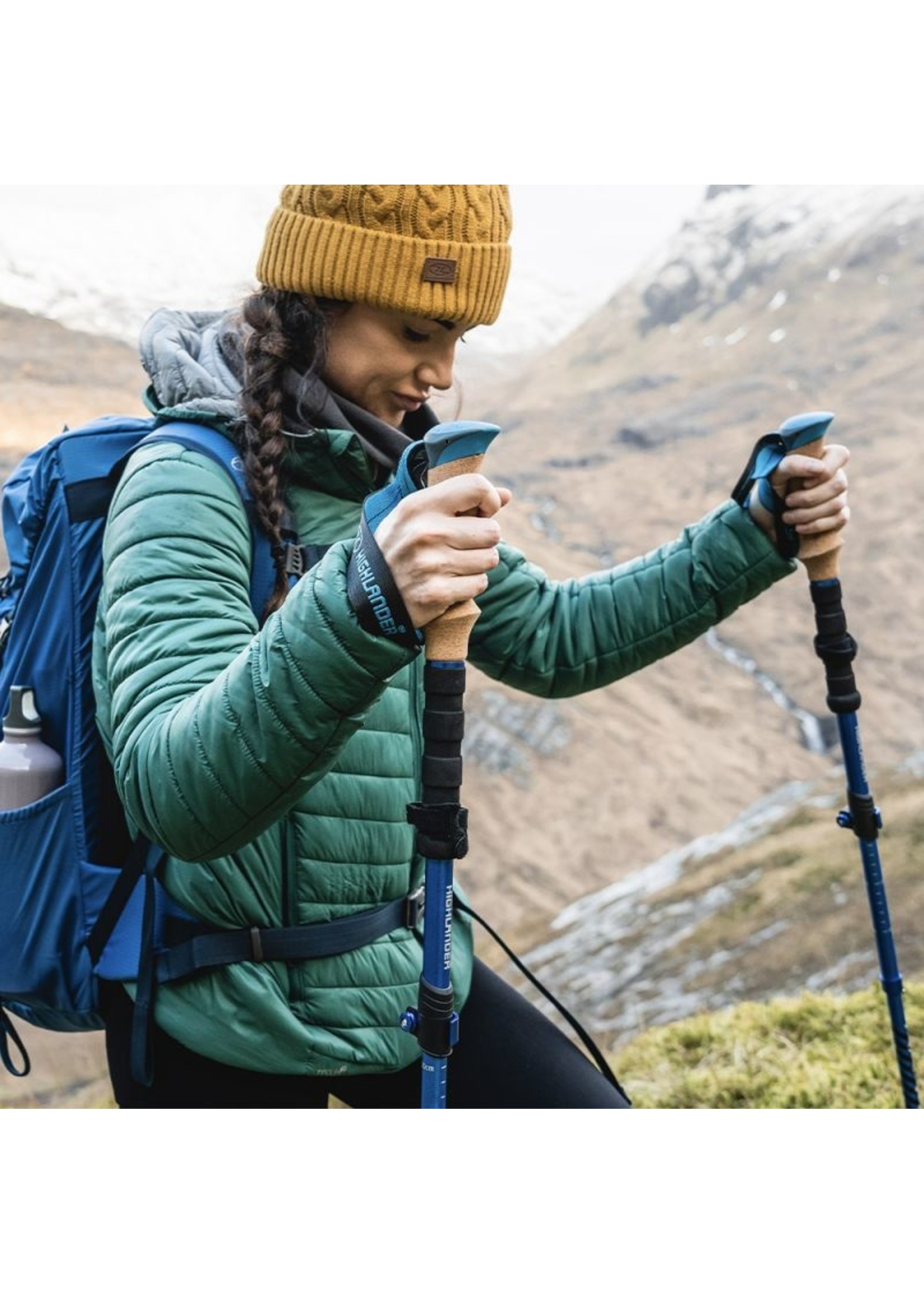 A Girl in Hiking Clothes with Trekking Poles Walks in the Mountains