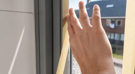 Glas van houten kozijn afplakken met tape op ongeveer een millimeter van de beglazingskit