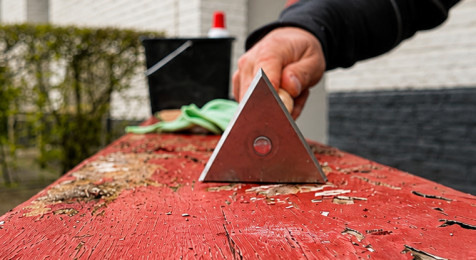 Losse verf en oude beits van een houten tuinbank verwijderen