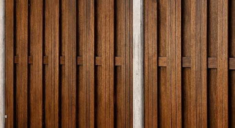 Tweede laag beits aanbrengen op een opgeknapte houten schutting