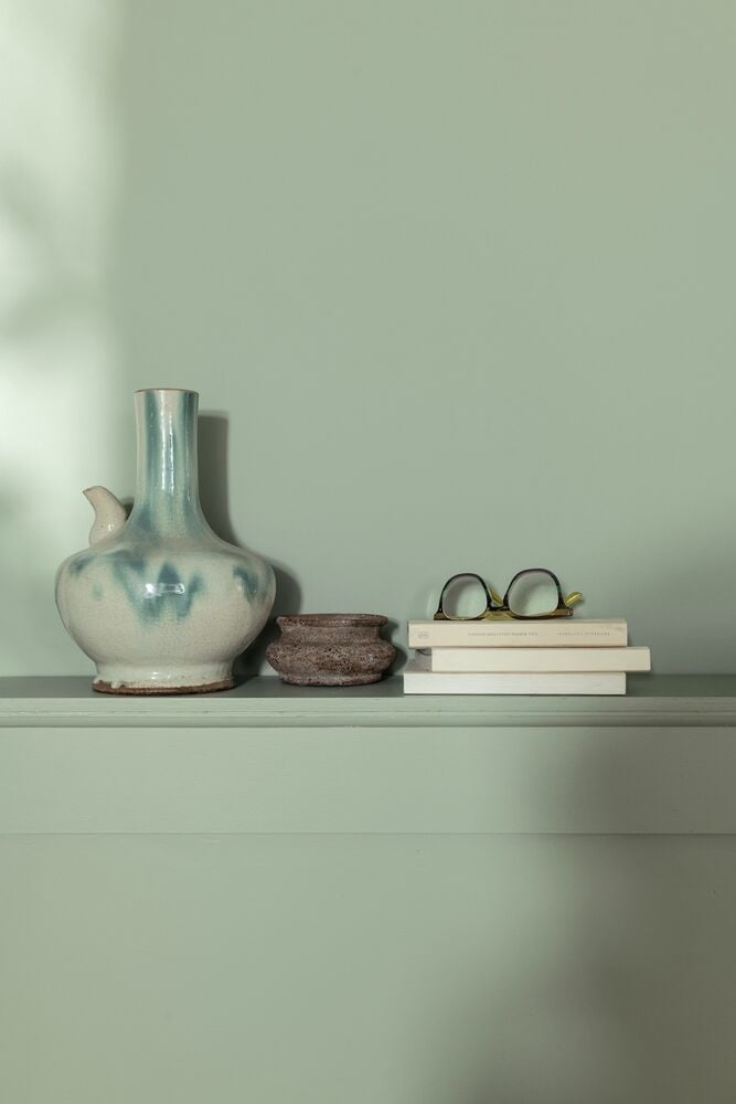 Interieurdetail met saliegroene wand en keramiek