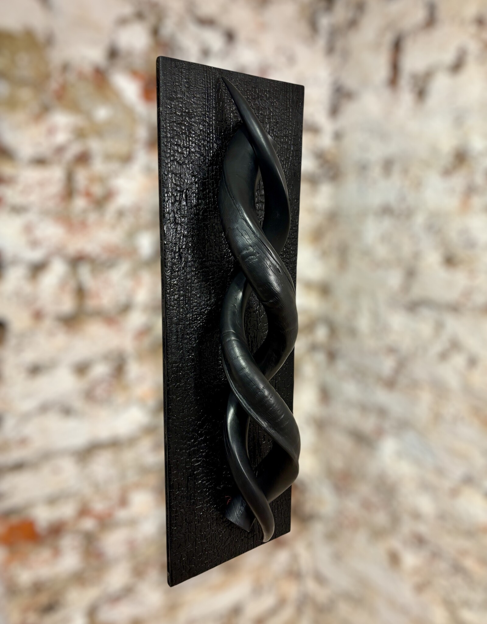 Designobjekt aus zwei echten Kuduhörnern – auf verbranntem Holz