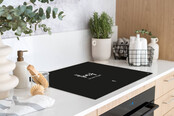Inductiebeschermer - zwart met tekst 'Thuis {hier woont ons geluk}' Inductiebeschermer - zwart met tekst 'Thuis {hier woont ons geluk}'