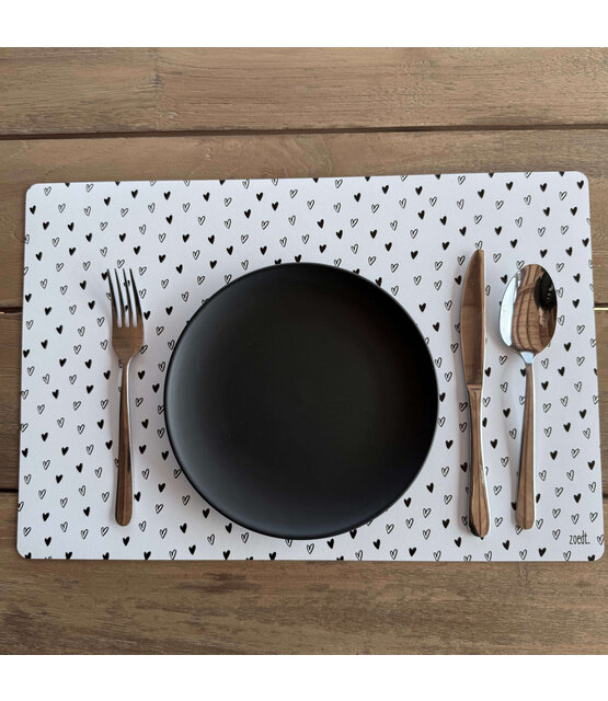 Placemat van wit vinyl met zwart hartjes patroon – een stijlvolle en praktische toevoeging aan jouw eettafel