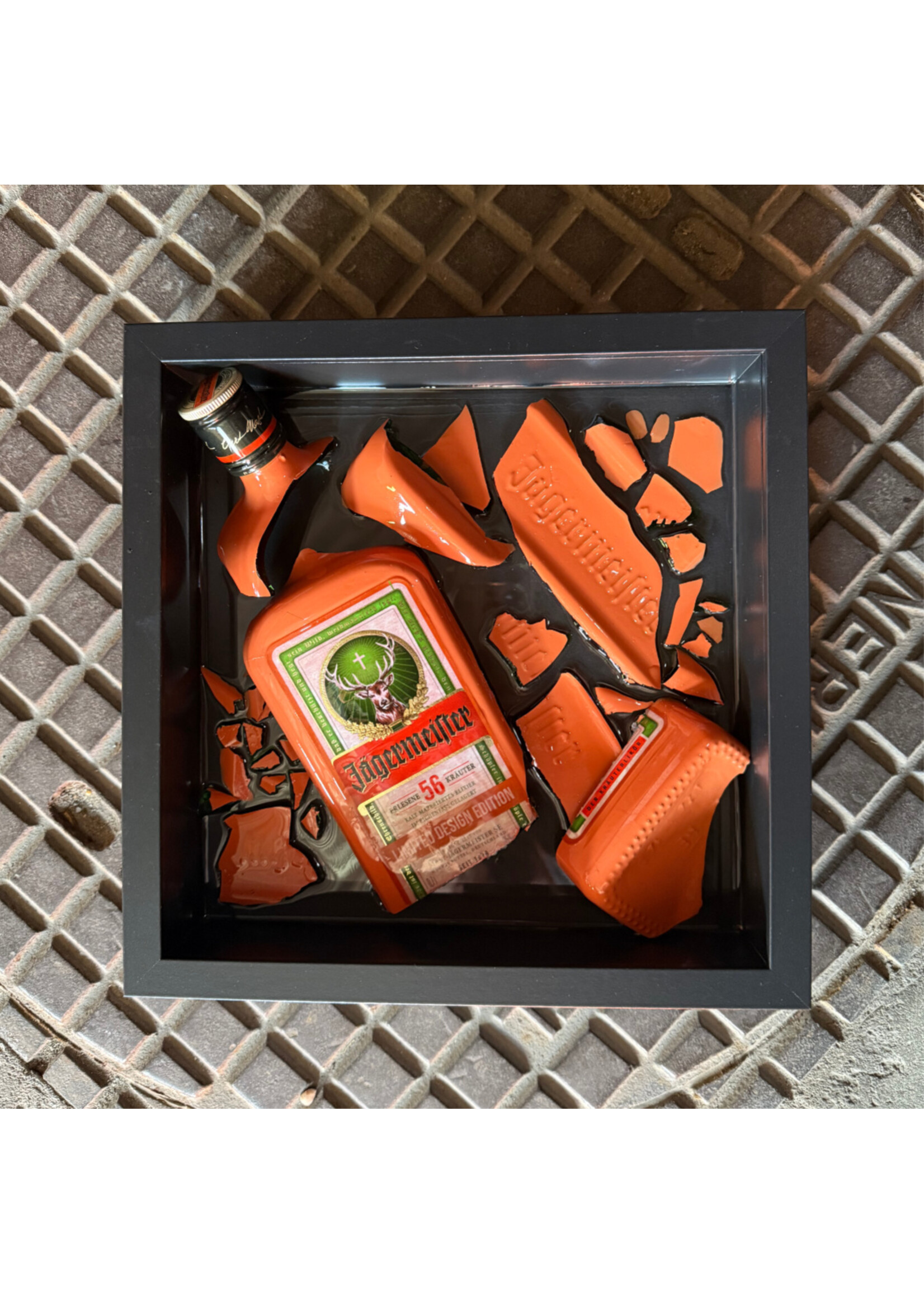 Kunstwerk in lijst met gebroken Jägermeister Limited Edition fles – gegoten in epoxy