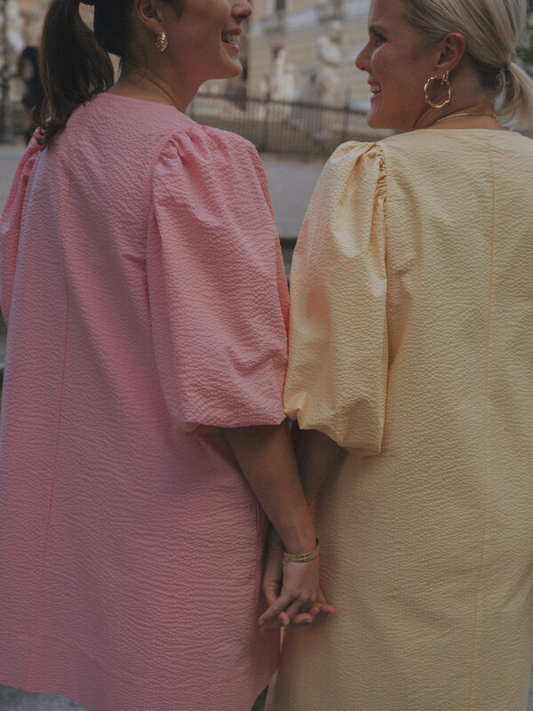 Les Soeurs Robe en seersucker Idris 3. Célébrez le printemps avec style avec cette robe rose à manches bouffantes. Son de...