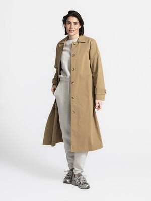 Lange jas Corrie. Coat check, please! Deze strakke trench is een ode aan de eenvoud. De tijdloze camelkleur werkt als neu...