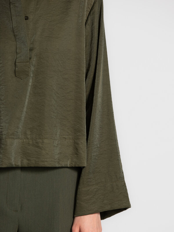 Selected Chemise courte Jean 4. Cette chemise courte en khaki profond respire l’élégance discrète. Sa brillance douce, se...