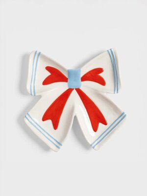 Bord Ribbon. Dit strikvormige bord in gebroken wit brengt een speelse en vrolijke twist aan je tafel. Elk handgeschilderd...
