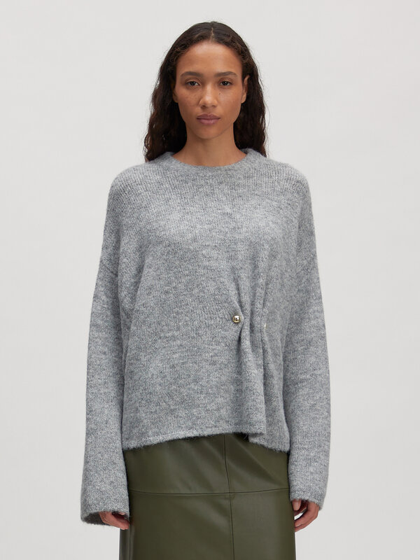 Edited Gebreide trui Noorie 2. Knit with a twist. Deze grijze gebreide trui valt op door het goud- en zilverkleurige fron...