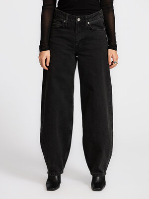Jean Marisse. Ce jean ballon noir en denim délavé allie silhouette décontractée et taille haute flatteuse. Sa teinte légè...