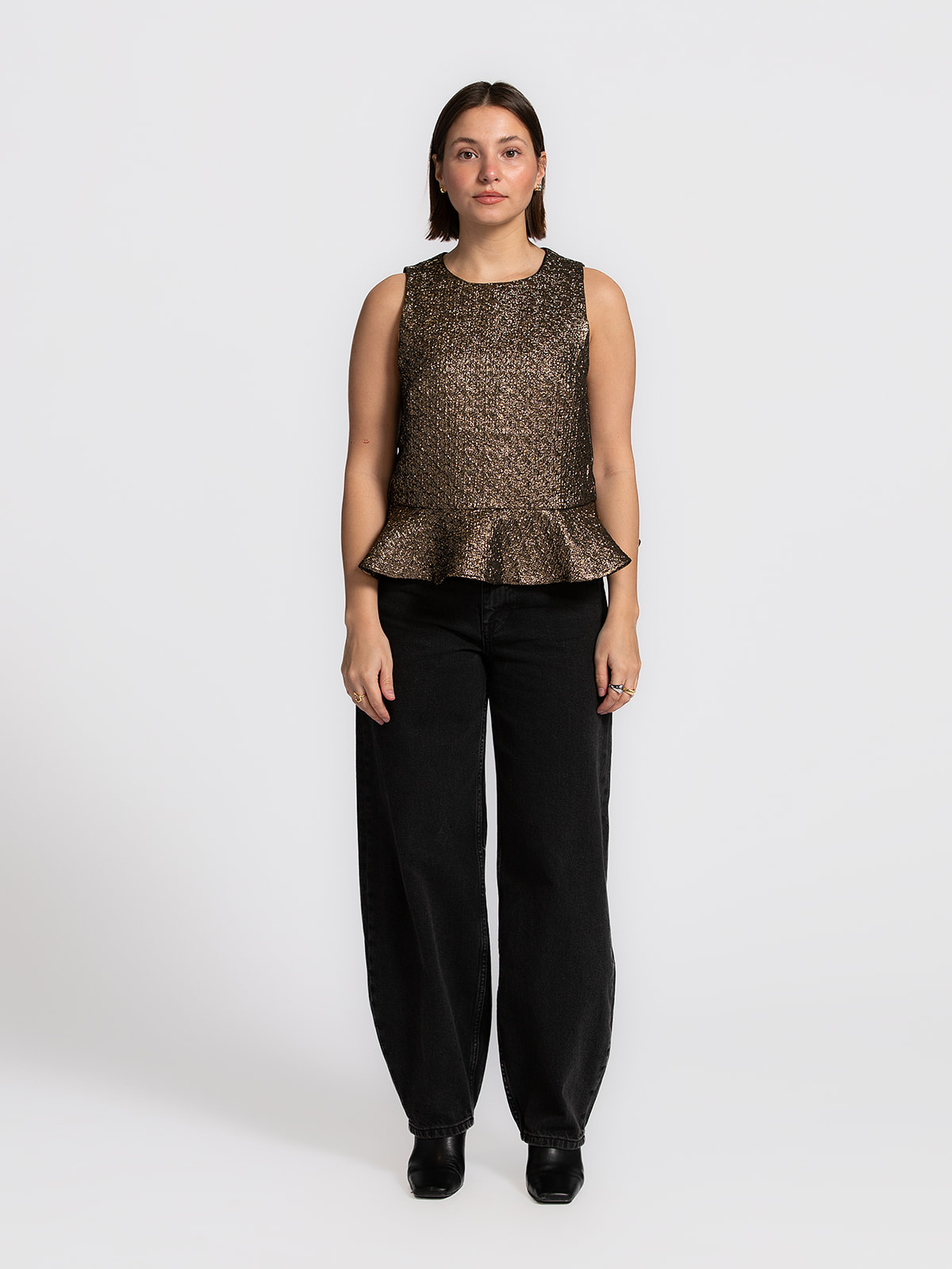 Edited Top sans manches Freya 3. Éclat doré. Ce top peplum sans manches doré associe une coupe trapèze féminine à un subt...