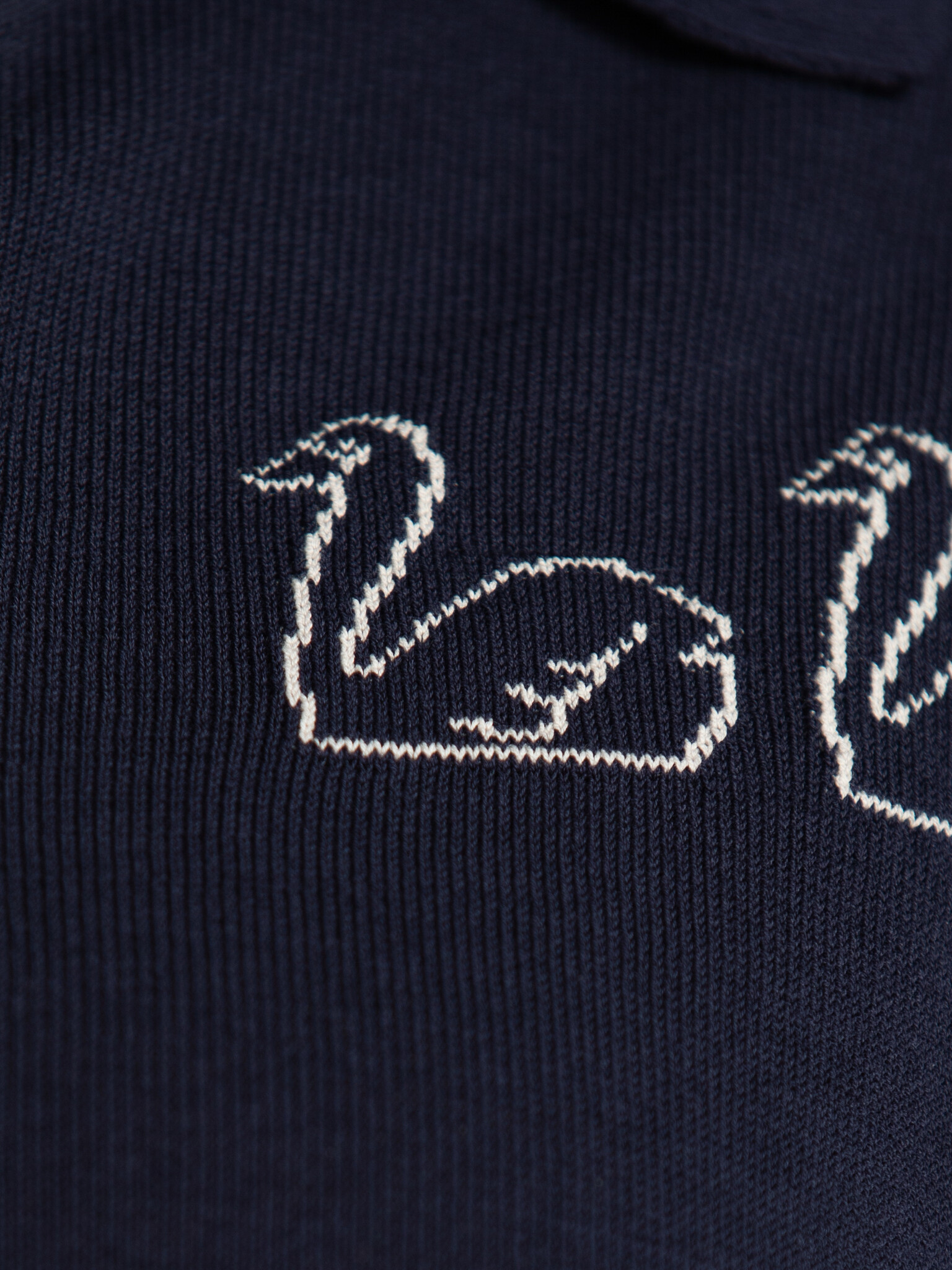 The tiny big sister polo en maille Swans 5. Classique avec une touche ludique. Cette polo tricotée avec une broderie swan...