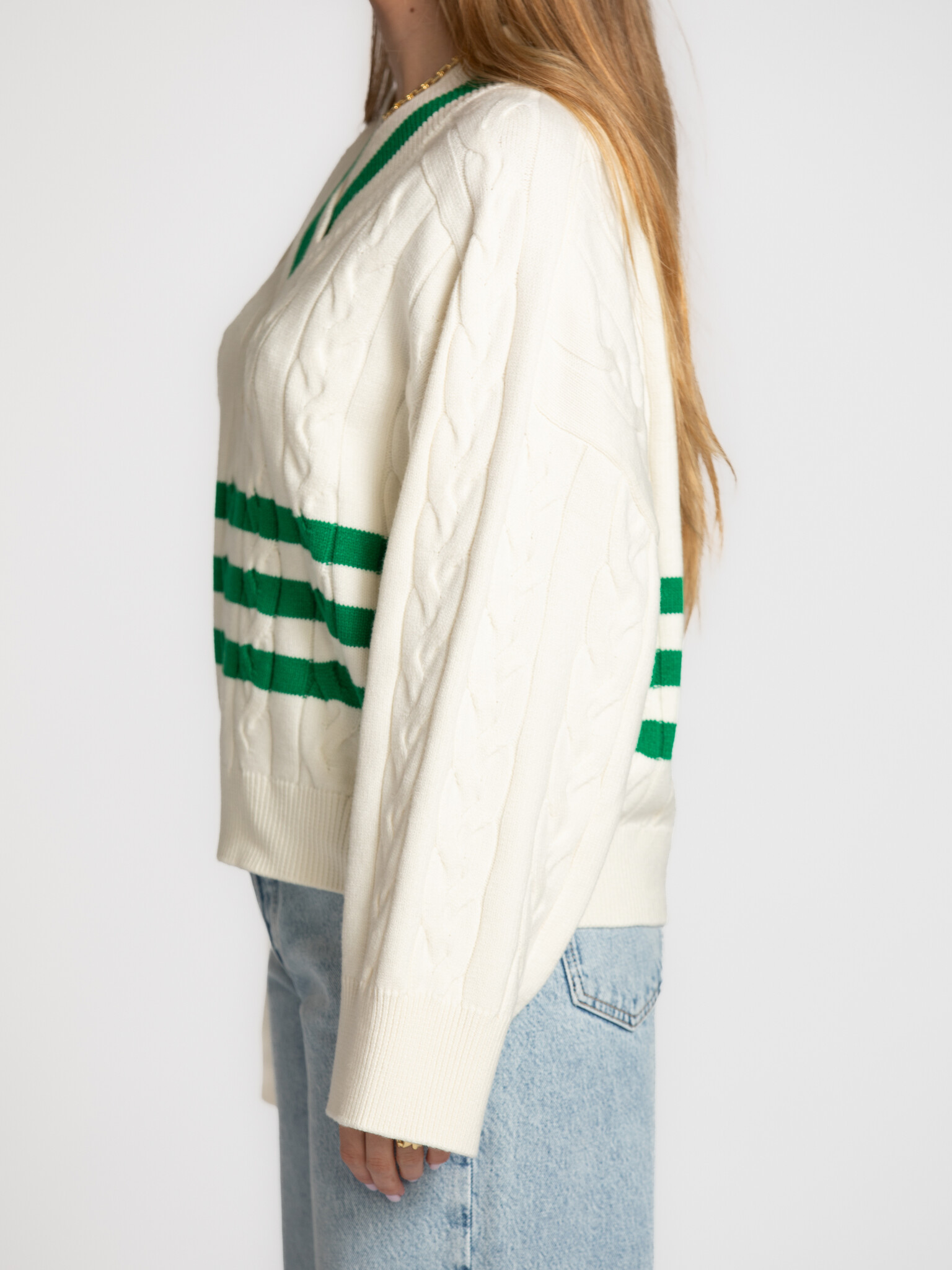 Edited kabeltrui Charline 4. Timeless with a sporty twist. De combinatie van kabelbreisel en groene details maakt deze tr...