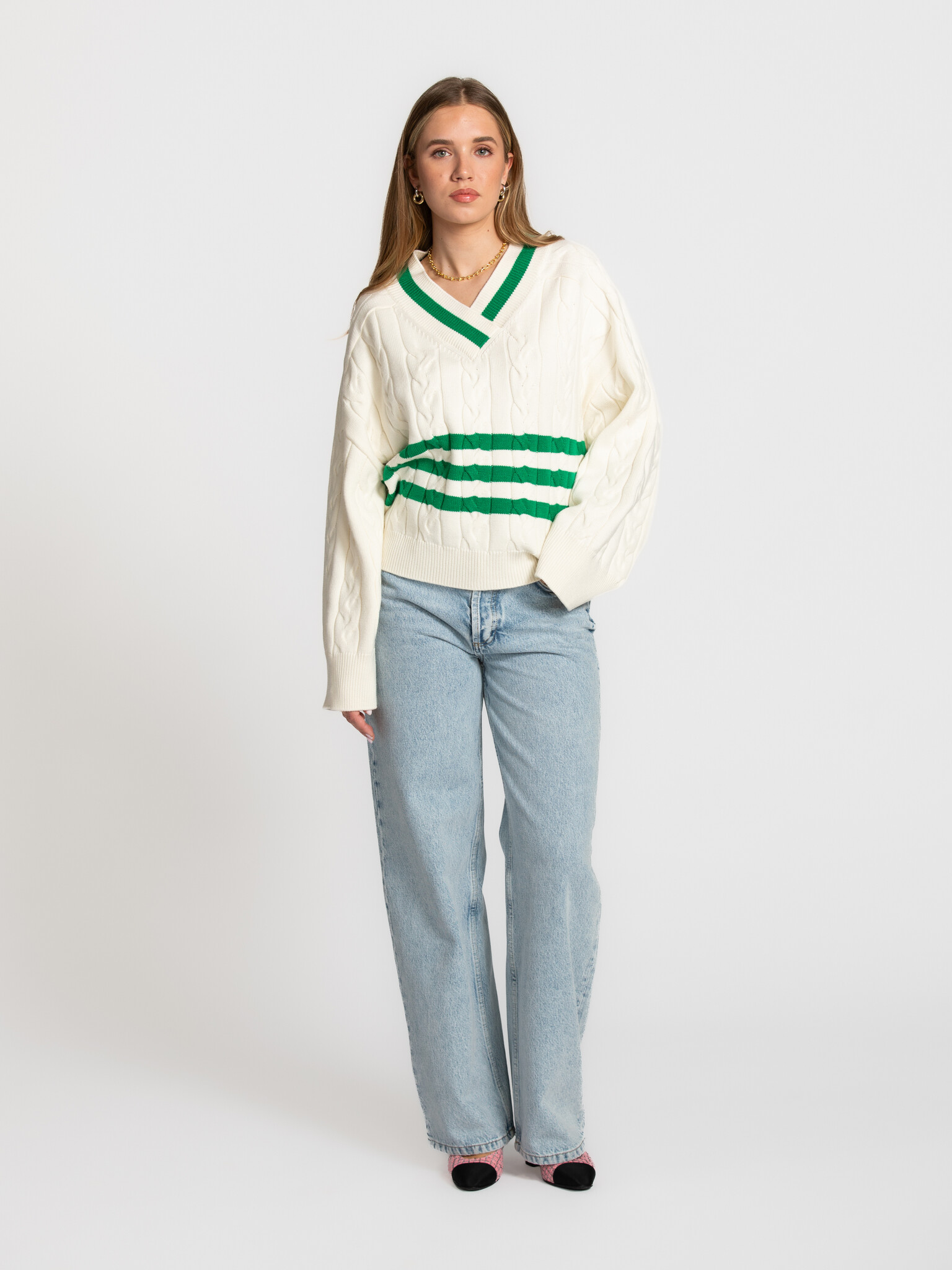 Edited kabeltrui Charline 3. Timeless with a sporty twist. De combinatie van kabelbreisel en groene details maakt deze tr...