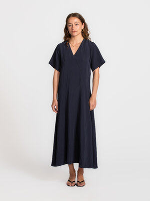 Jurk Iona. Een maxi jurk die moeiteloos met je meebeweegt en een zachte flow creëert bij elke stap. Ze draagt je van plek...