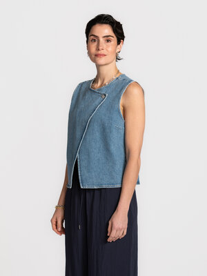 Top Vida-Kori. Een mouwloze top in denim met een subtiele asymmetrische sluiting die meteen karakter geeft. Ze valt ontsp...