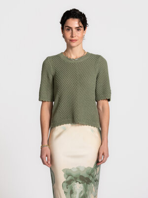 Top Carla Eloven. A touch of green. Deze gebreide top straalt zachtheid en eenvoud uit. De subtiele structuur en korte mo...