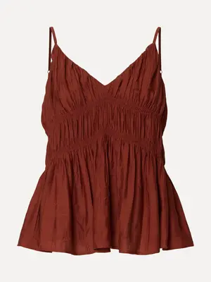 Top Jackie. De charme zit in de details. De gesmokte afwerking geeft deze top een zachte beweging en een ontspannen uitst...