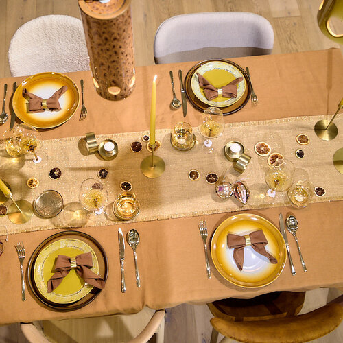 Au coin du feu – une table de Noël chaleureuse aux teintes ambrées, sublimée par des touches dorées et une douce lueur.