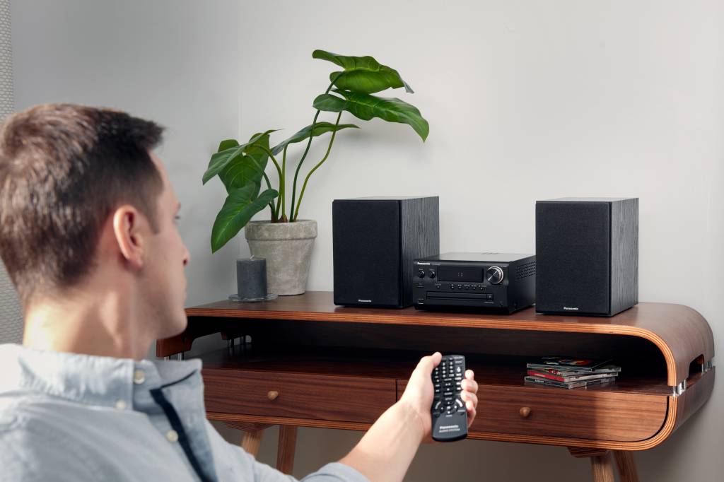 man turning up a stereo during a party