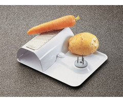 Vegetable scraper on foot with fixation nails