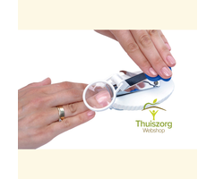 Nail clippers on suction cups with magnifying glass for one-handed use