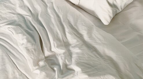 Hoe het hoeslaken rondom je deken doen?