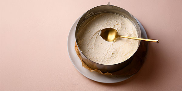 Tortenring und Creme mit Löffel darin verteilen