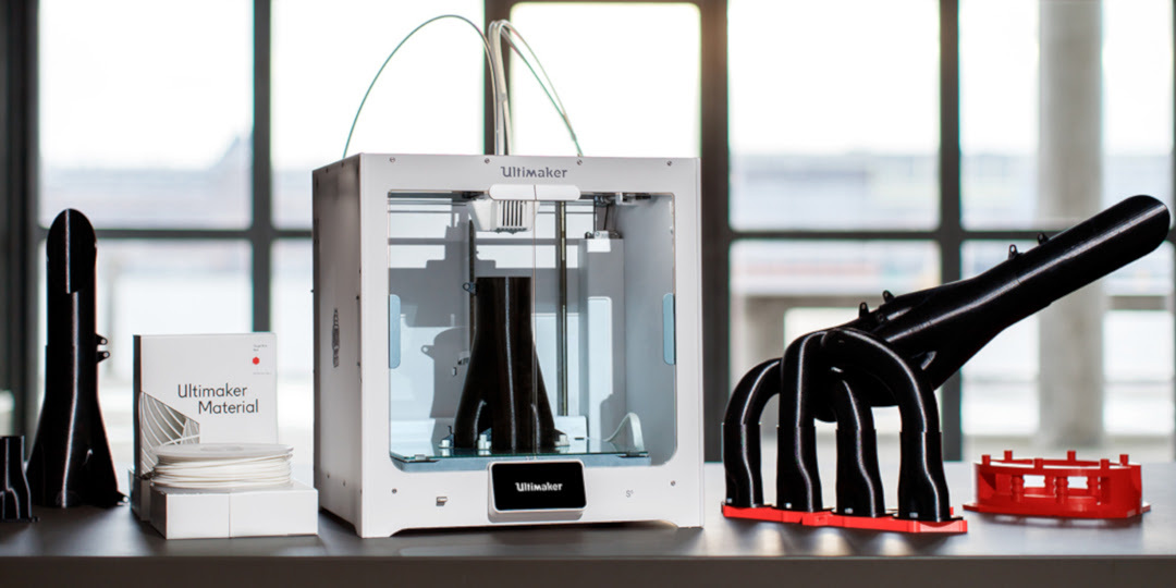 Ultimaker S5 on a table surrounded by 3D printed pieces