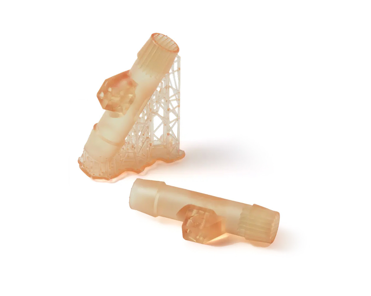 Prototipos de dispositivos médicos de color ámbar translúcido, impresos en 3D con resina biomédica biocompatible, que se muestran con estructuras de soporte.