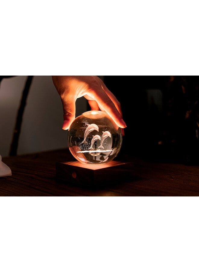 Globe lumineux en cristal ambré représentant des dauphins sautant