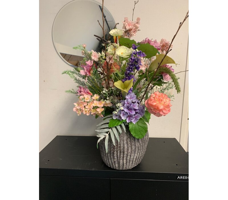 Kleurrijk bloemstuk met zijdebloemen in moderne vaas