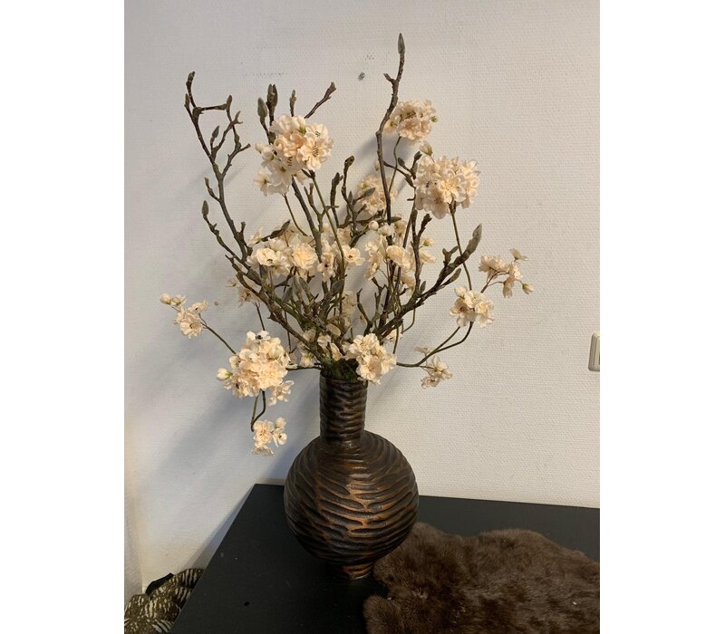 Vaas met bloesem takken in zachte tinten