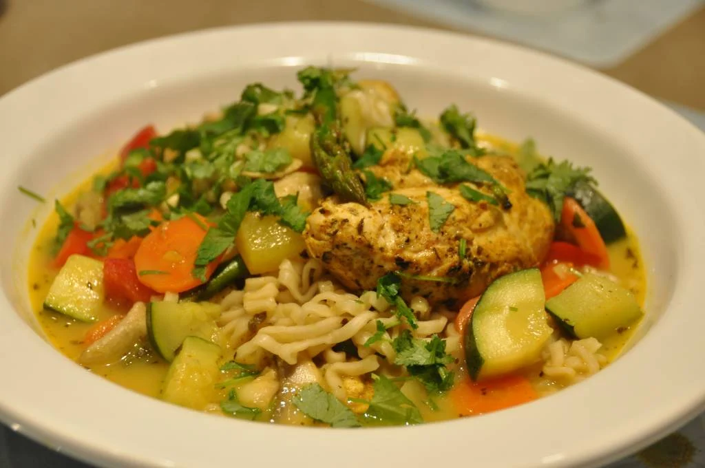 Frische Delhi-Curry-Suppe mit Nudeln und Hühnchen im Wok