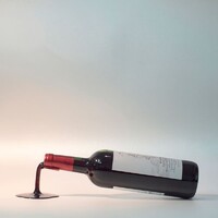 Wine bottle holder Fall in Wine red - gloss, shaped like a spill of wine