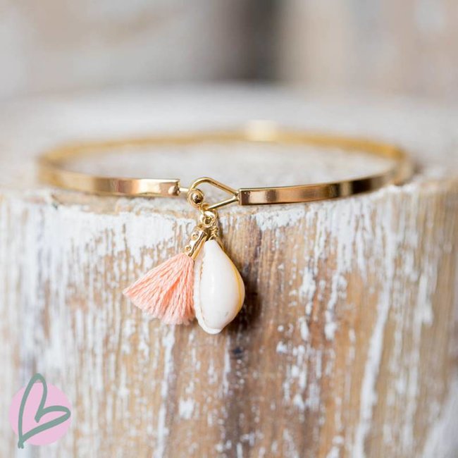 Beadle Goudkleurige platte armband met cowrie schelp en peach kwastje